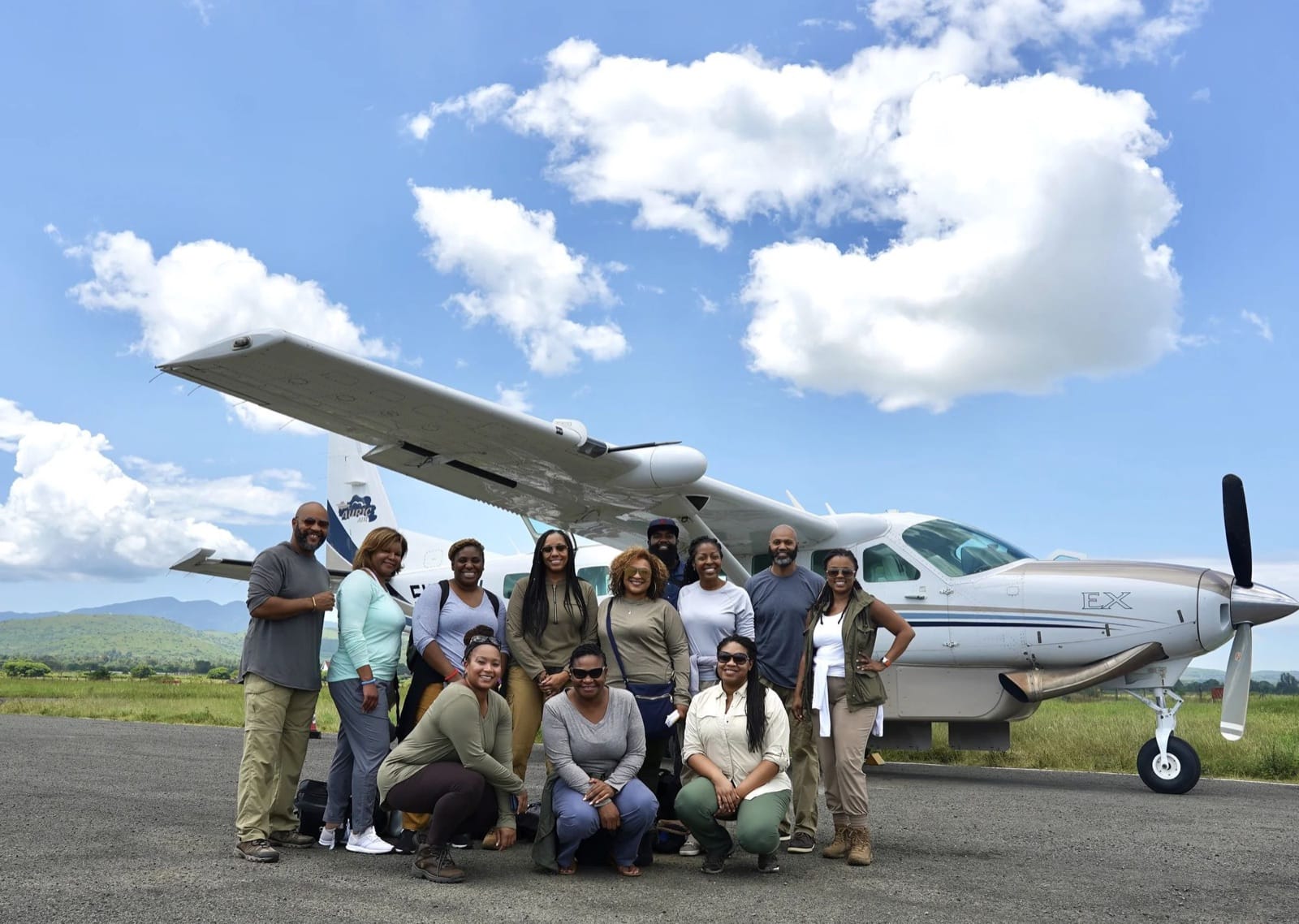 Caviar in the Air travelers in safari clothes beside a small charter plane on a Tanzania airstrip